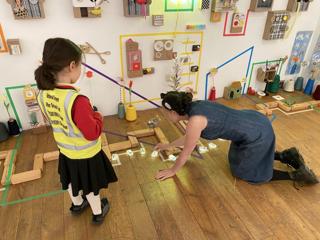 Children from Bethnal Green After School Club creating collective sculpture of miniature houses with artist Charlotte Mew at ELF Festival of Creative Health