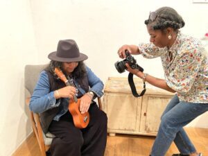Visitors at the Playtime Corner photo booth choosing cards from the Creative Health Photo Game at Four Corners Gallery